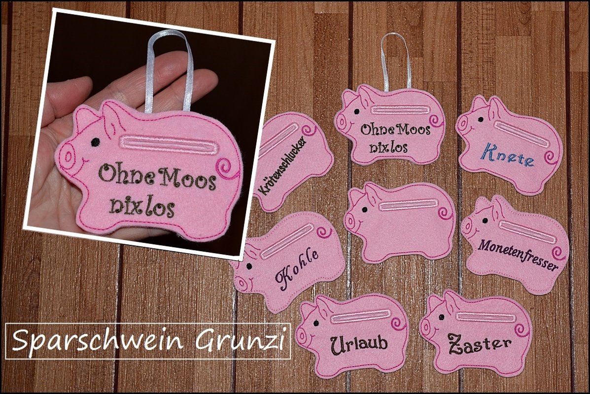 Mehrere rosa Filz-Sparschwein-Anhänger mit Geldschlitz und gestickten Sprüchen, eines davon in einer Hand gehalten.