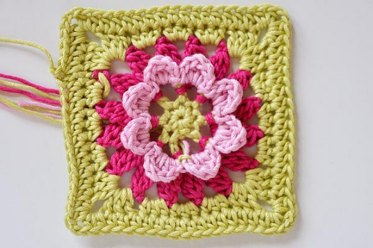 Häkel-Granny-Square mit rosa Blüte und hellgrünem Rahmen