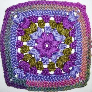 Gehäkeltes Granny Square in Lila, Blau und Grün mit Blumenmitte