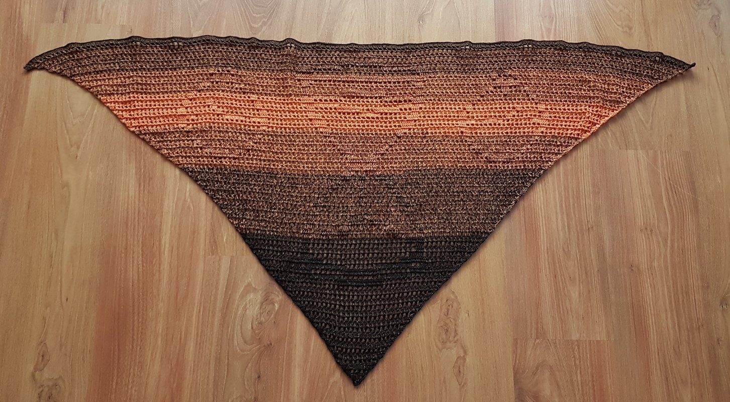 Gehäkeltes Dreieckstuch mit Braun‑Orange Farbverlauf auf Holzfußboden