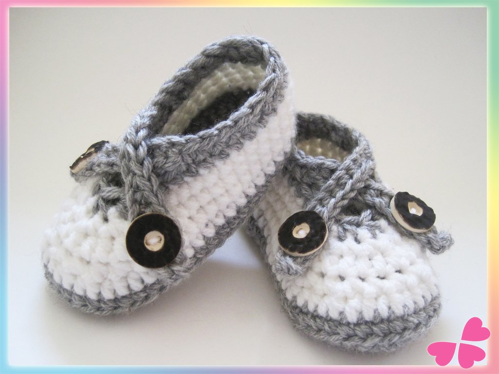 Gehäkelte weiße Babyschuhe mit grauem Rand und Knopfriegel