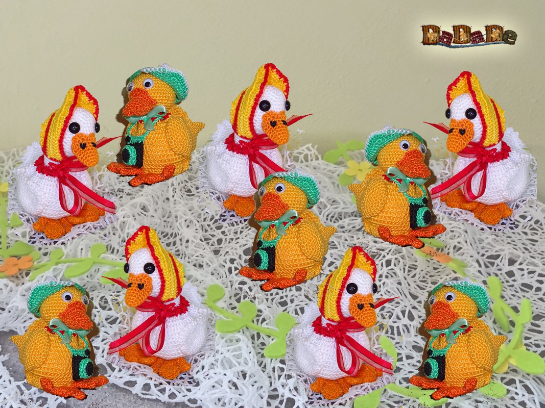 Neun gehäkelte Amigurumi-Enten und Küken mit Mützen, Schleifen und Mini-Kameras