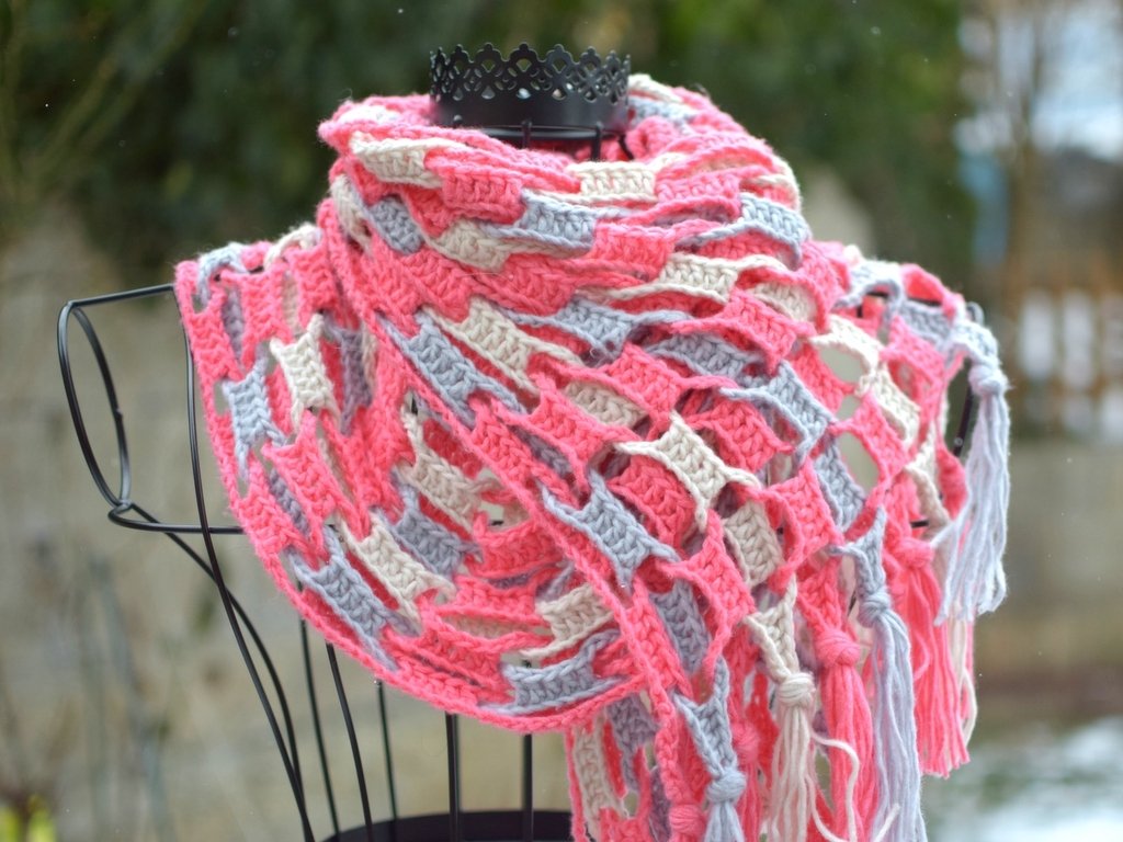 Mehrfarbiger gehäkelter Schal mit offenem Gittermuster und Fransen auf einer Schneiderbüste