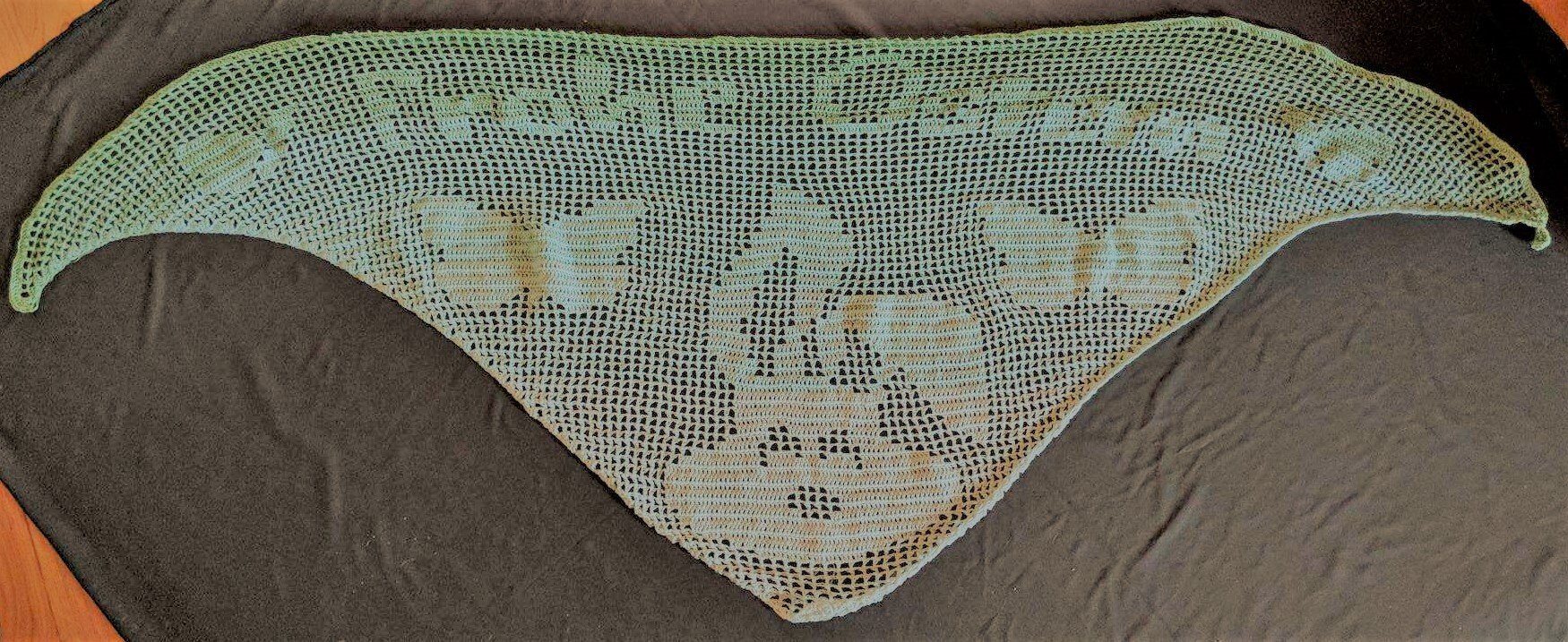 Dreieckiges filet
gehäkeltes Tuch mit zentralem Hasenmotiv und dekorativen Mustern entlang der Kante