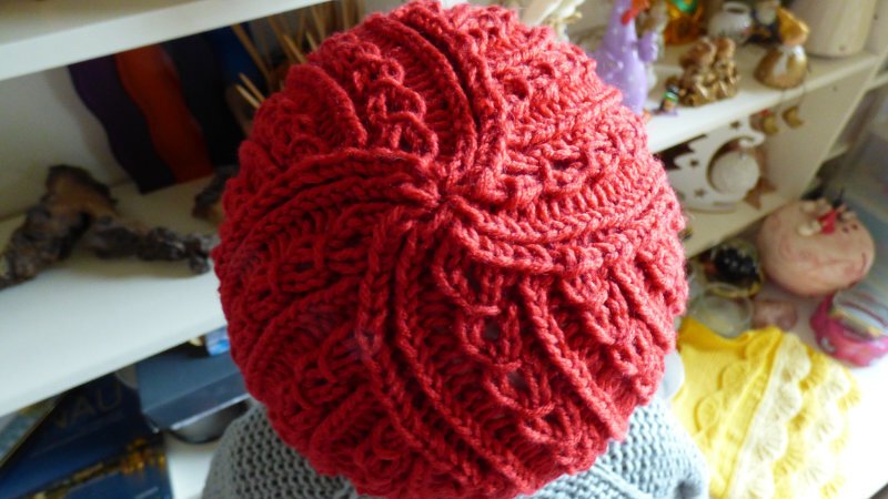 Draufsicht auf rote gestrickte Zopfmütze mit sternförmiger Abnahme