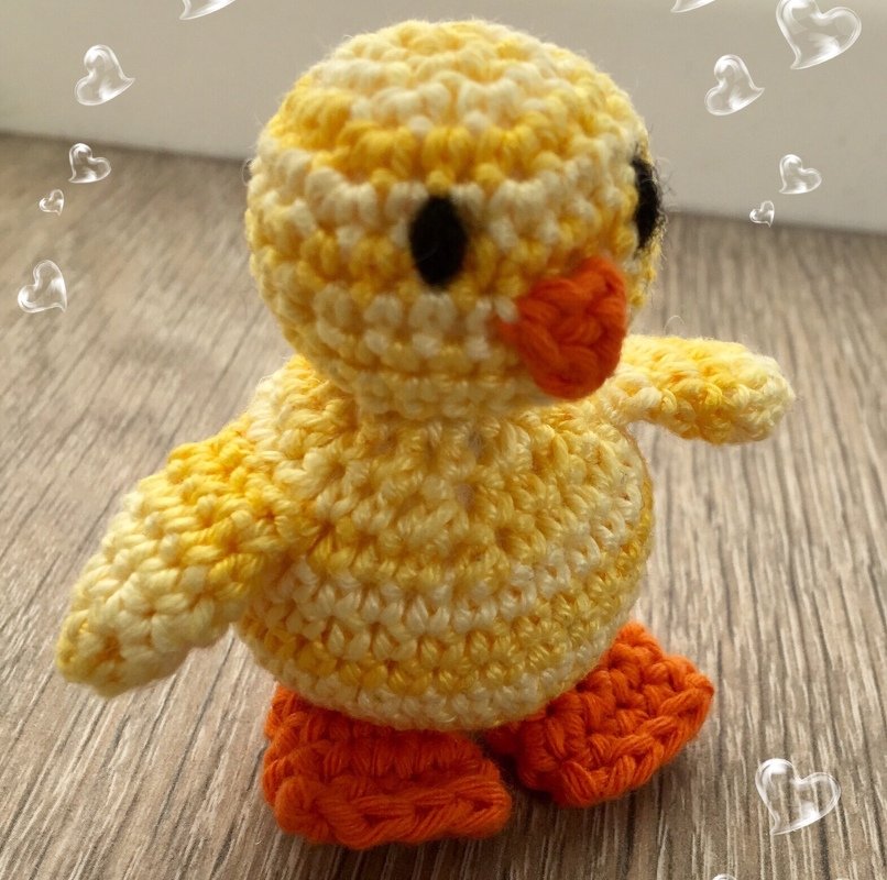 Gehäkeltes gelbes Amigurumi-Küken mit orangefarbenem Schnabel und Füßen