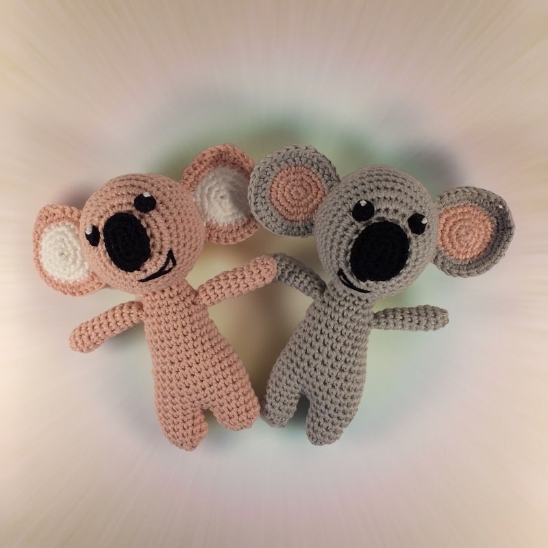 Pastellfarbene gehäkelte Koala-Amigurumi, rosa und grau, nebeneinander