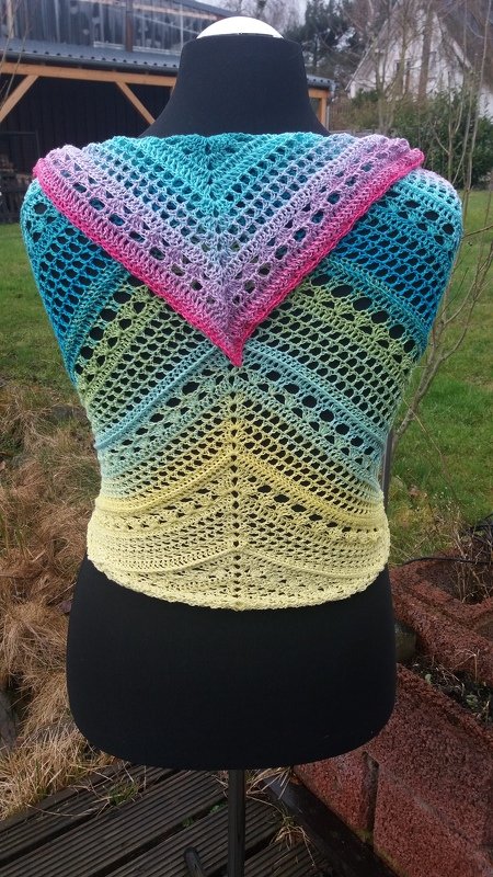 Buntes gehäkeltes Dreieckstuch auf einer Schneiderpuppe mit Farbverlauf von Pink zu Gelb und offenem Lochmuster.