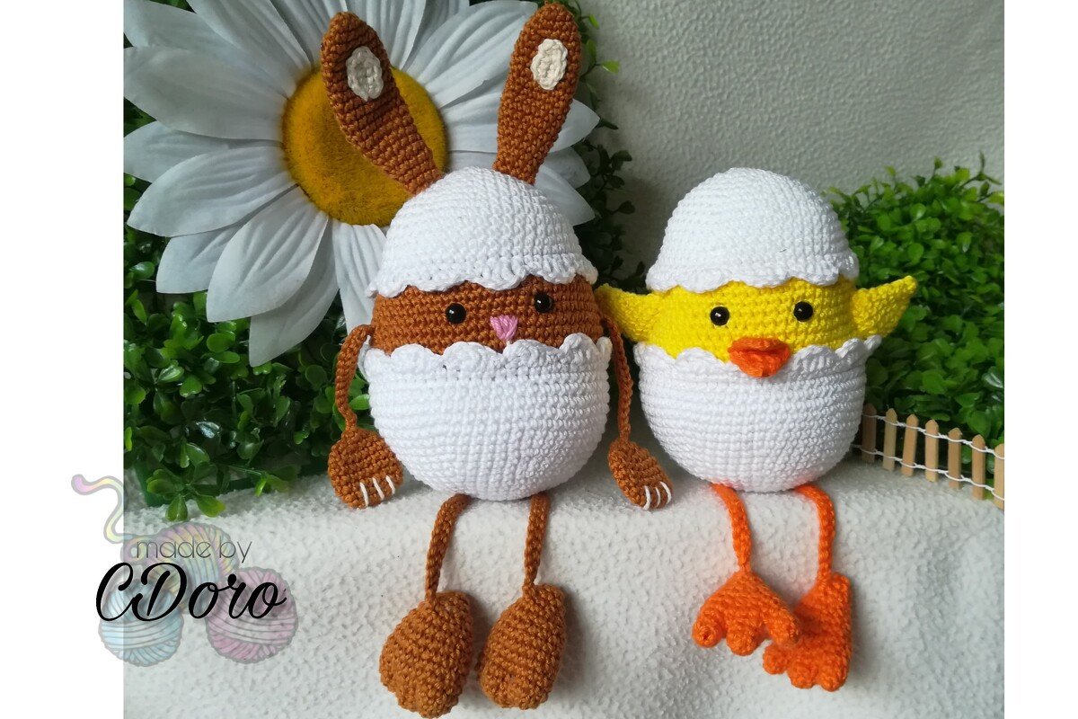 Crocheted brown bunny and yellow chick amigurumi in white eggshells