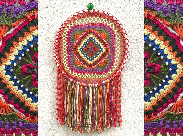 Boho-Häkelmedaillon auf Ring mit bunten Fransen an heller Wand