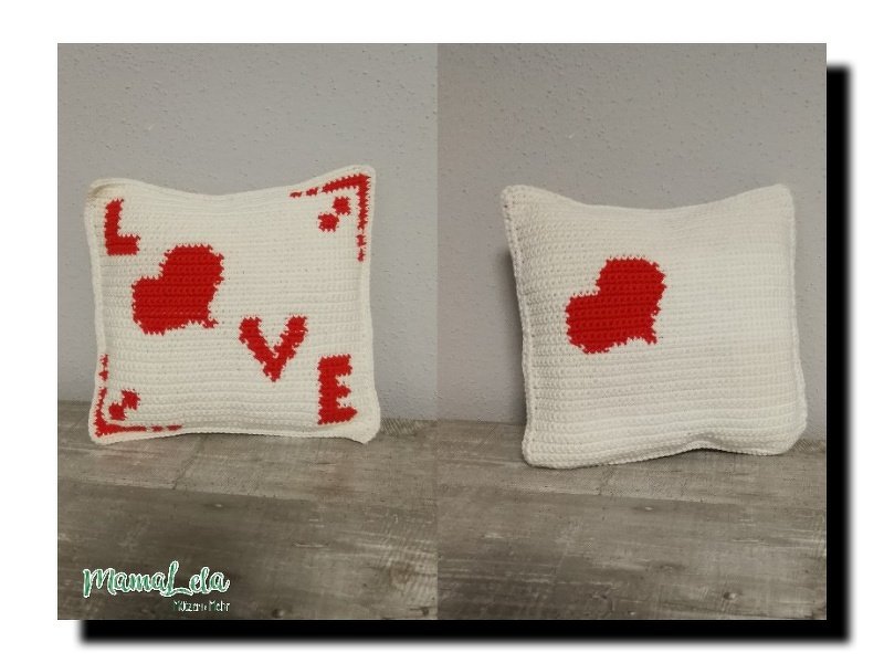 Zwei Ansichten eines gehäkelten Kissens in Weiß mit roten Motiven: Vorderseite mit LOVE-Schriftzug und Herz, Rückseite mit einzelnem Herz