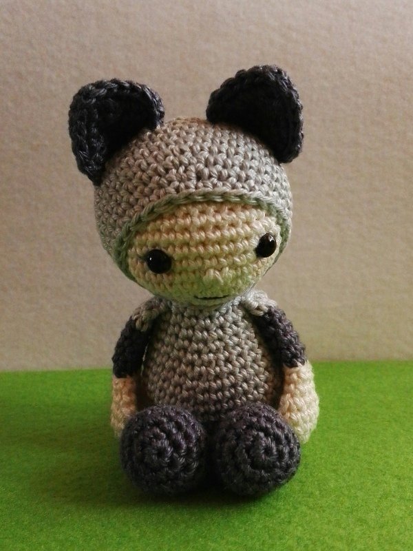 Vorderansicht einer gehäkelten Amigurumi-Katzenpuppe mit angefügten Ohren und kontrastierenden Armen