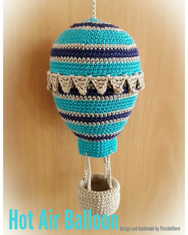 Gehäkelter Heißluftballon in Türkis, Dunkelblau und Beige, hängend mit kleinem Korb