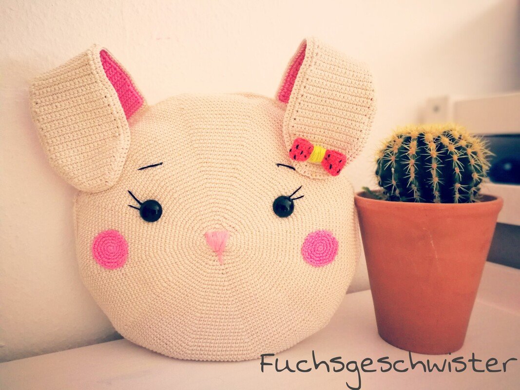 Gehäkeltes Hasenkissen beige mit rosa Akzenten und Kaktus im Topf