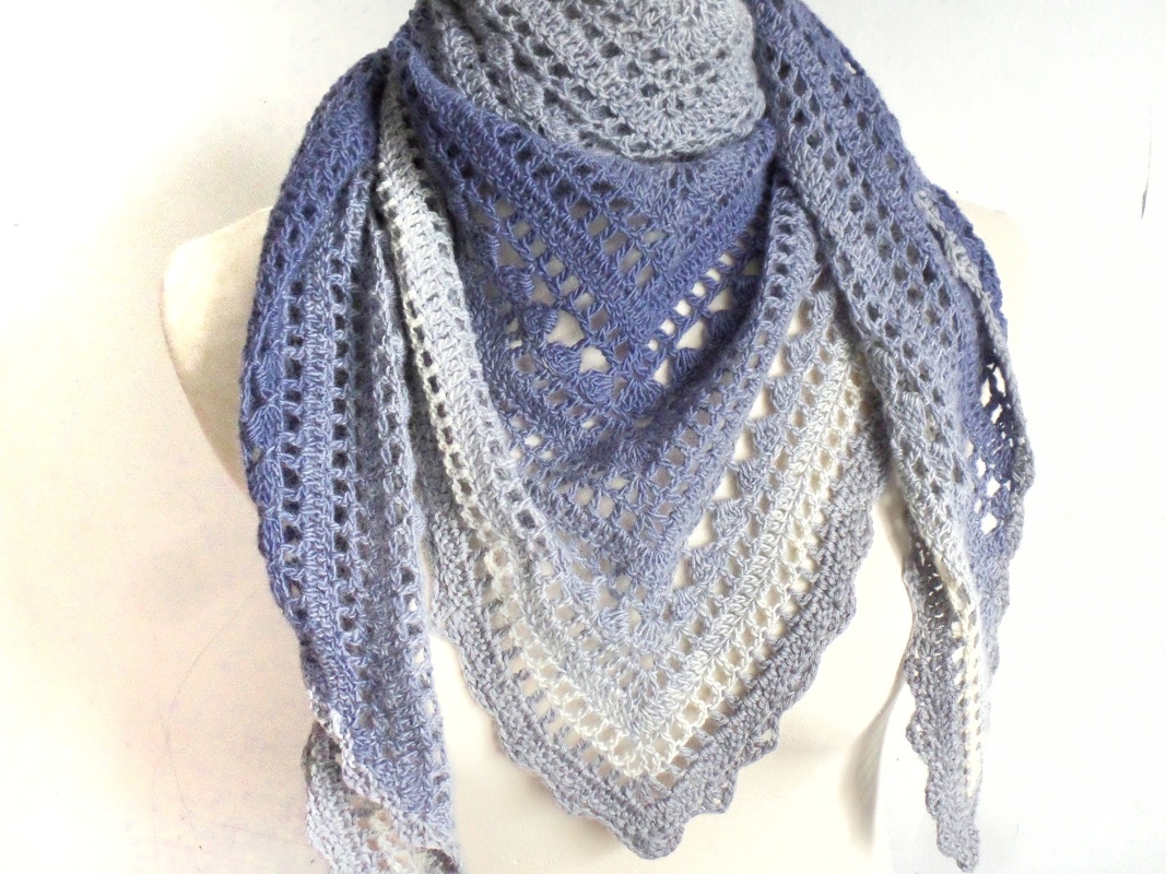 Gehäkeltes Dreieckstuch in Blau-Weiß mit Lochmuster, drapiert auf einer Schaufensterpuppe