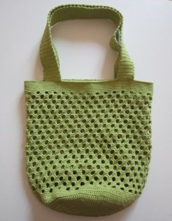 Lindgrüne gehäkelte Netztasche mit offenem Maschenbild und breiten Henkeln