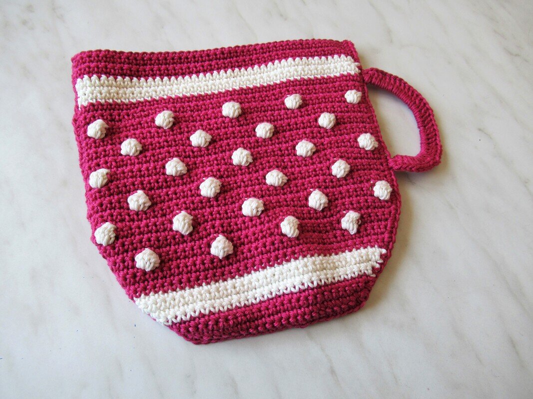 Gehäkelter Topflappen in Pink mit weißen Noppen und Aufhängeschlaufe