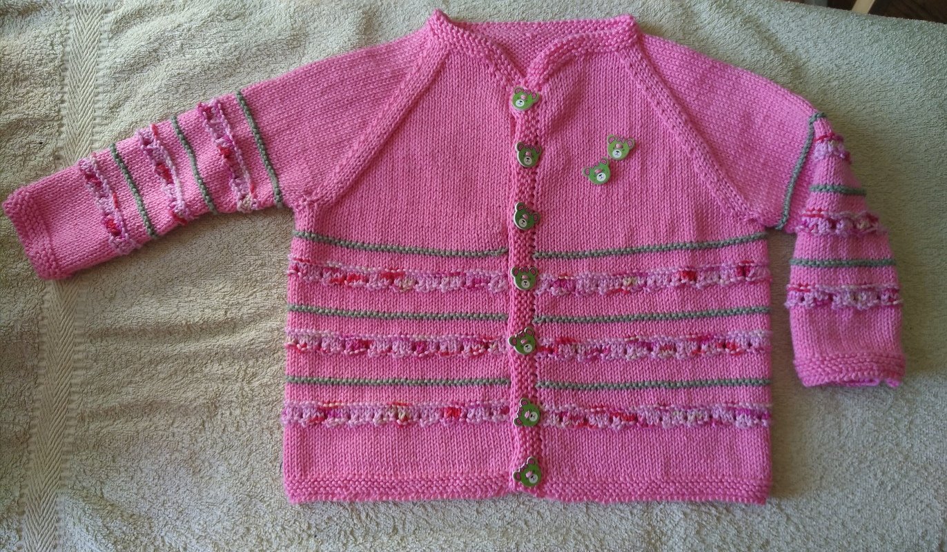 Handgestrickte rosa Babyjacke mit grünen Bärenknöpfen und Musterstreifen