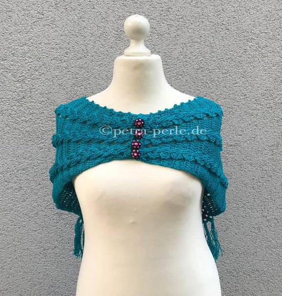 Türkiser gehäkelter Bolero mit drei rosa Knöpfen auf einer Schaufensterpuppe