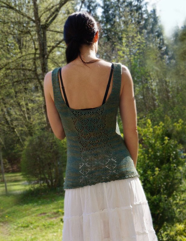 Rückenansicht einer Frau in grünem gestricktem Top mit Spitzeneinsatz und weißem Rock