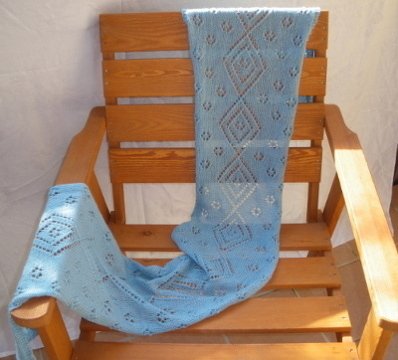 Hellblauer gestrickter Schal mit Ajour-Diamantmuster auf Holzstuhl