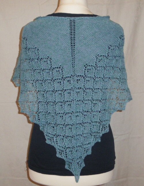 Gestricktes Dreieckstuch mit mittiger Lochreihe, Ajourmustern und gezacktem Rand auf einer Schaufensterpuppe