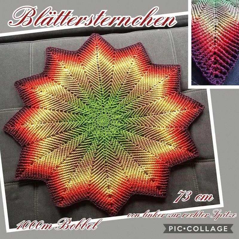 Sternförmige Häkeldecke mit Farbverlauf in Grün, Gelb, Orange und Rot auf grauem Sofa.