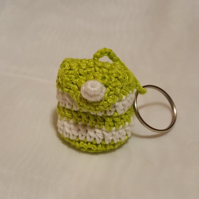 Gehäkelte Mini‑Tasche in limettengrün und weiß mit Knopfverschluss und Schlüsselring