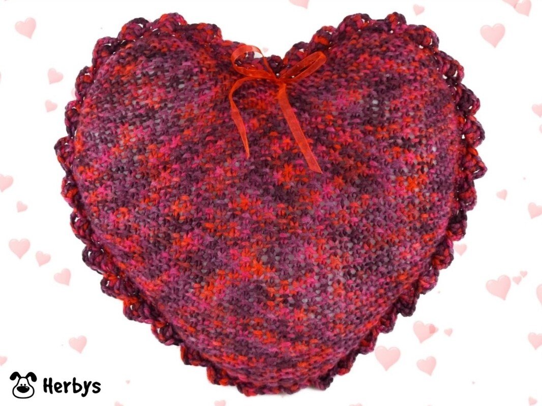 Romantisches gestricktes Herzkissen in Rot- und Pinktönen mit Muschelrand