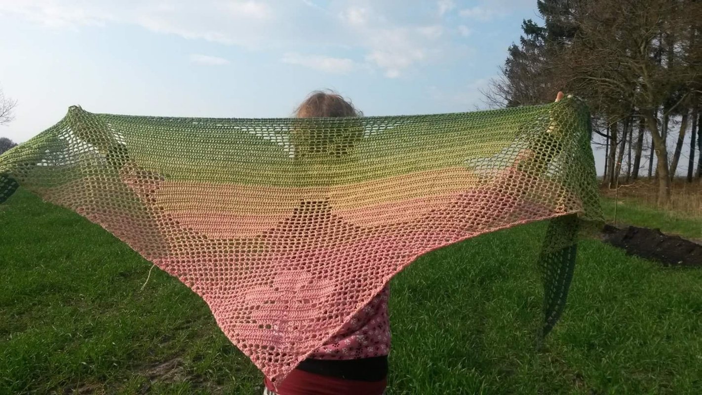 Gehäkeltes dreieckiges Motivtuch mit offenem Netzstich und mittigem Blütenmotiv, Farbverlauf von Grün zu Rosa