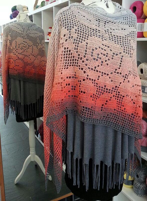 Motivtuch mit Reihen aus Spitzenmustern, Farbverlauf und Fransen auf einer Schneiderpuppe vor Garnregalen