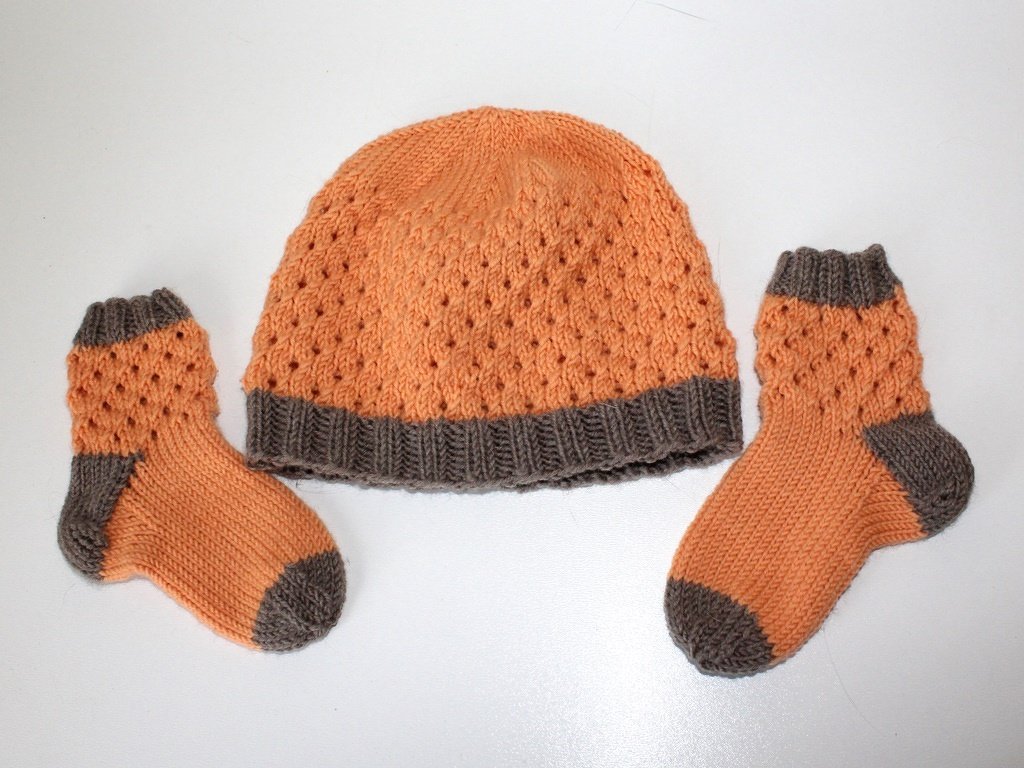 Baby-Mütze und zwei Söckchen, Orange mit grauen Bündchen und Lochmuster