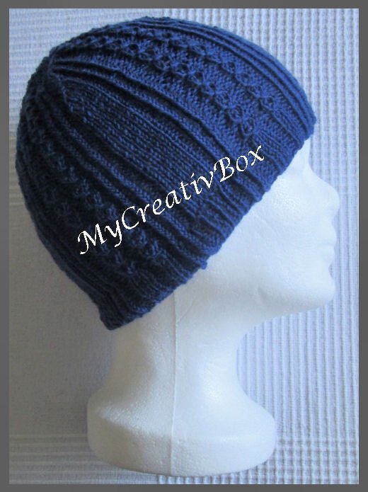 Dunkelblaue Strickmütze mit Rippen- und Strukturmuster auf einem weißen Kopfmodell, Seitenansicht.