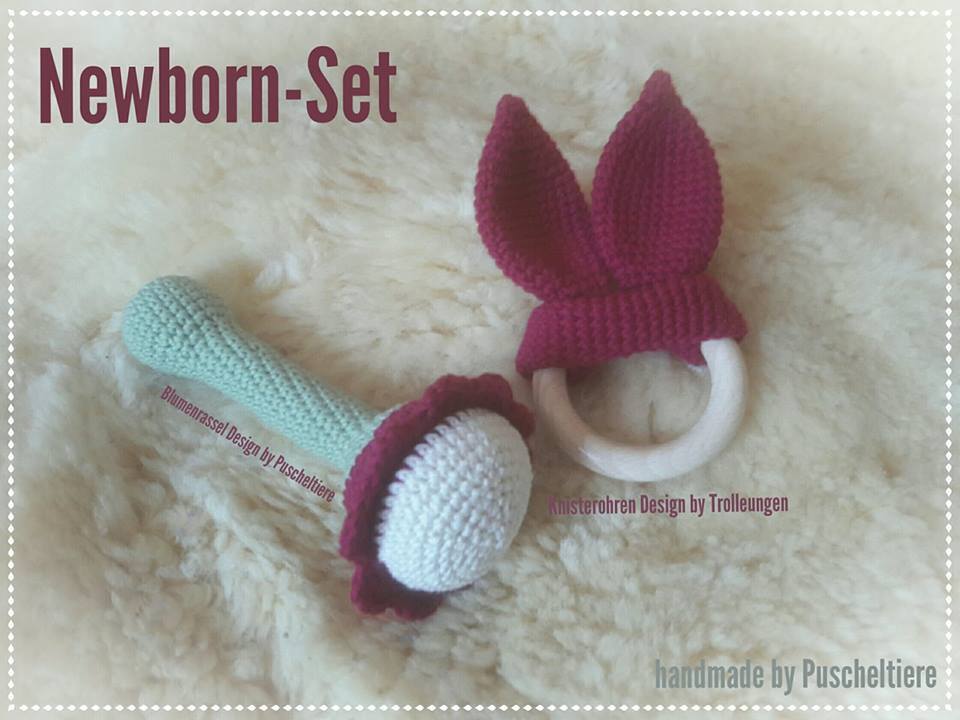 Gehäkelte Blumen-Rassel in Mint und Beißring mit gehäkelten Hasenohren auf hellem Fell