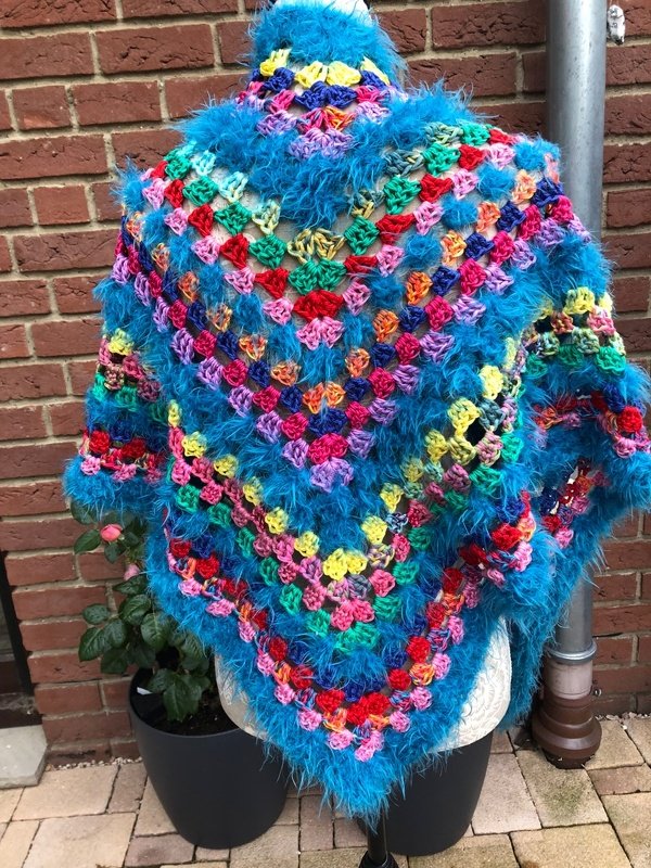 Buntes gehäkeltes Dreieckstuch aus Granny-Squares mit blauem Flauschrand auf einer Schaufensterpuppe