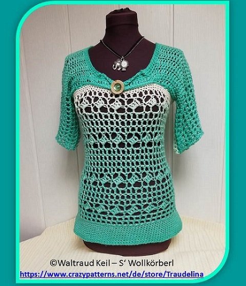 Türkis‑weißes gehäkeltes Damen‑Shirt mit Lochmuster, Dreiviertelärmeln und Zierknopf auf Mannequin