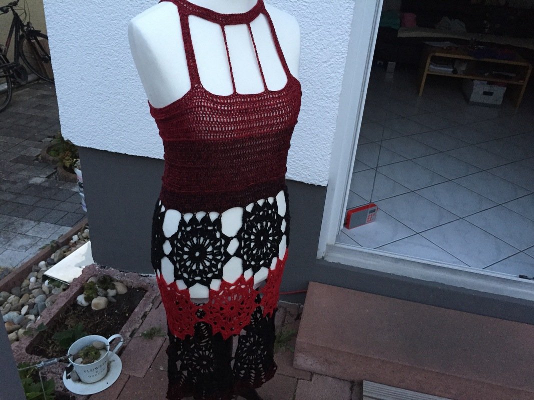 Gehäkeltes Rot‑Schwarz Kleid auf Schaufensterpuppe mit Neckholder‑Oberteil und Mandala‑Lochmuster im Rock