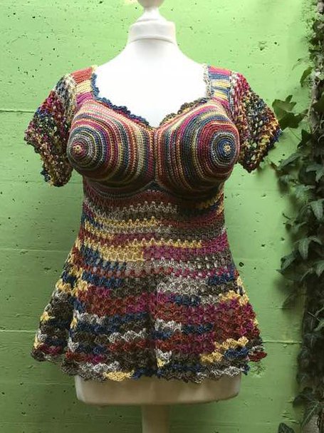 Mehrfarbiges gehäkeltes Bustier-Top mit spiralförmigen Cups und kurzen Ärmeln auf einer Schaufensterpuppe.