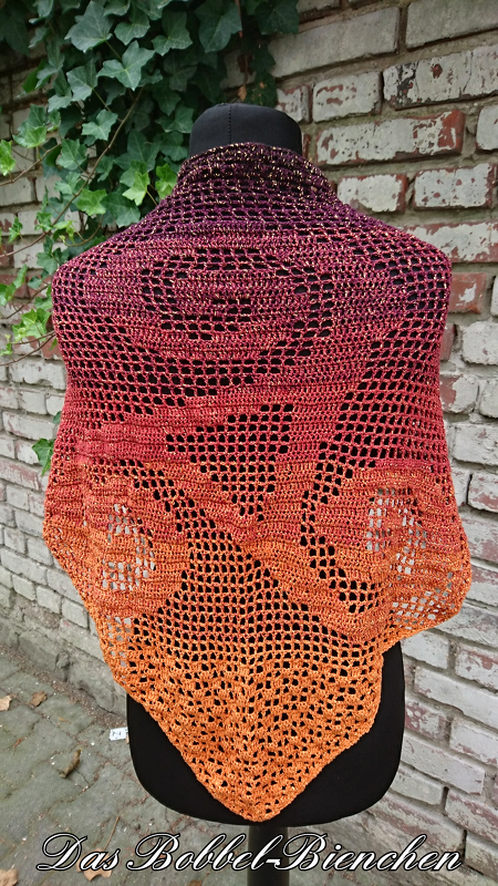 Gehäkeltes Dreieckstuch Violett–Orange auf schwarzer Schaufensterpuppe vor Ziegelwand