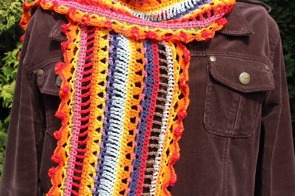 Mehrfarbiger gehäkelter Schal mit Streifen und Muschelrand über brauner Cordjacke