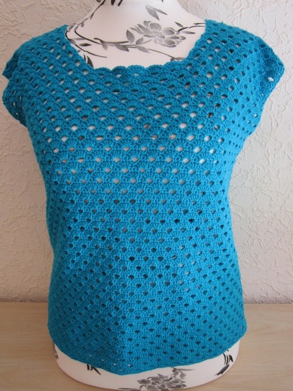 Türkise gehäkelte Tunika mit Muschel- und Ajourmuster auf einem Mannequin