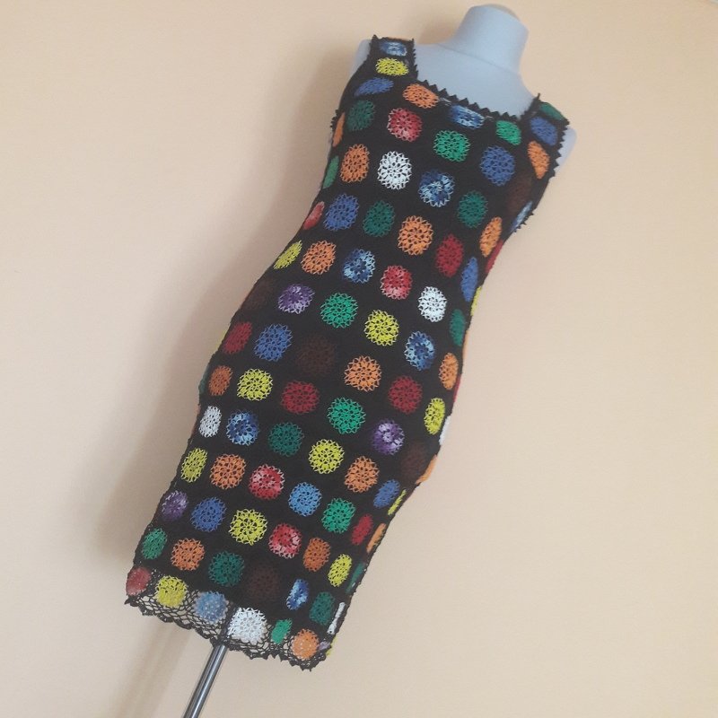 Knielanges schwarzes Häkelkleid auf Schaufensterpuppe mit bunten runden Häkelmotiven