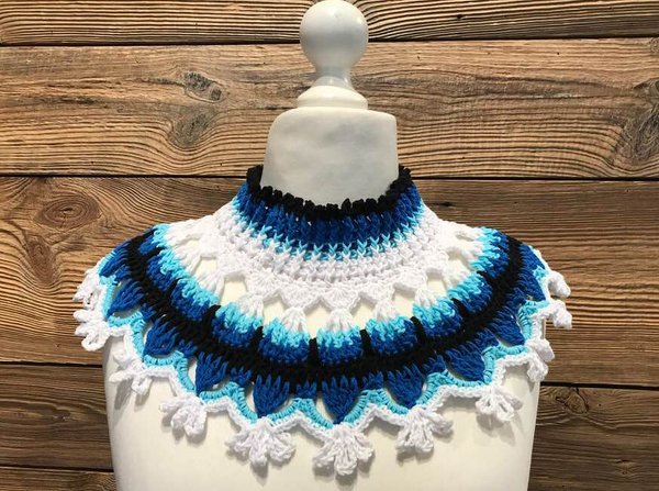 Gehäkelter Kragenschal in Blau, Weiß und Schwarz auf Schaufensterbüste vor Holzwand