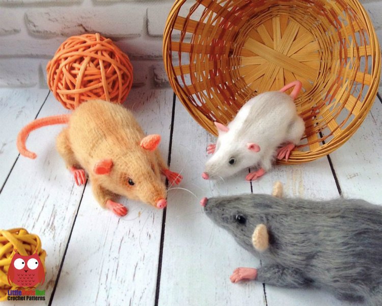 Three small crocheted amigurumi rats in different colors shown with a wicker basket and decorative balls