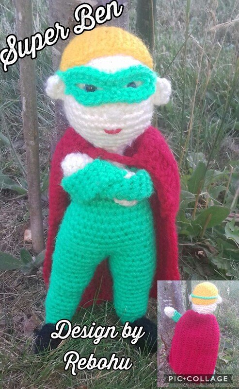 Gehäkelte Amigurumi-Superheldenpuppe in Rot, Grün und Gelb auf Gras