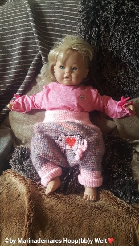 Babypuppe in melierter gehäkelter Hose mit hohem Bund und Herzdetail