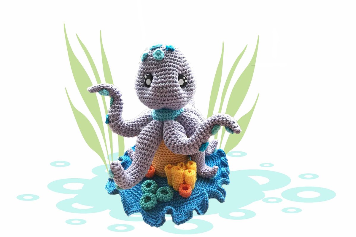 Gehäkelter lila Oktopus-Amigurumi mit türkisfarbenen Akzenten, blauer Basis und gehäkelten Korallen