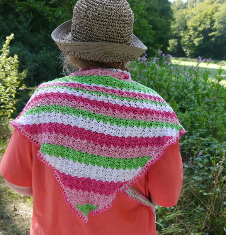 Rückenansicht einer Person mit gehäkeltem Dreieckstuch in Rosa, Weiß und Grün