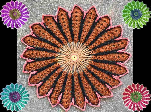 Große braun-schwarz-korallfarbene gehäkelte Blume mit vier kleineren Blumen in Lila, Grün, Türkis und Pink auf grauem Hintergrund.