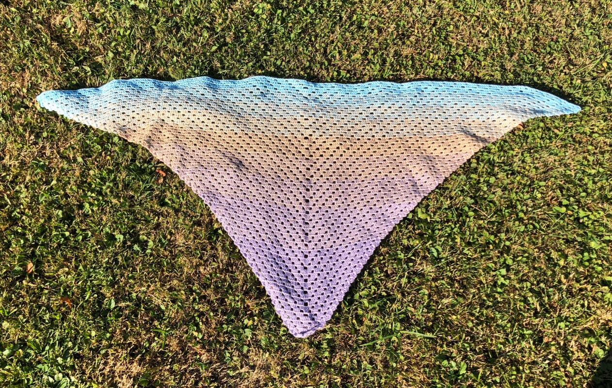 Gehäkeltes Dreieckstuch mit Farbverlauf auf Gras